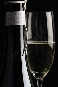 Prosecco 蛋白饮料瓶子玻璃香槟酒精酒杯黑色背景气泡背景图片