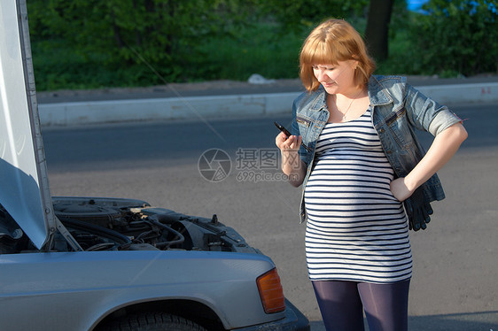 孕妇在破车附近呼救请求帮助兜帽维修车辆金发电话发动机手套故障挑战城市图片