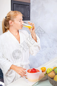 妇女在厨房喝新鲜果汁图片