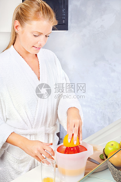 女人在厨房做早间果汁水果奇异果早餐金发橙子微笑女性食物长袍图片