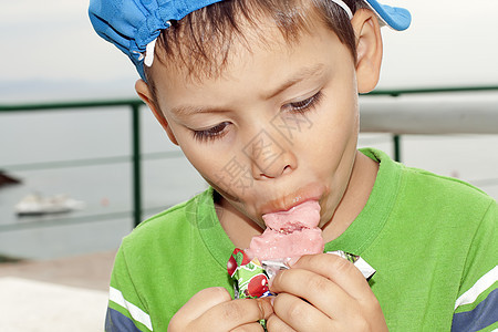 小男孩吃冰淇淋码头水果甜食沙滩孩子食物孩子们背景图片