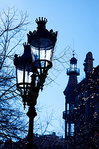 巴塞罗那街灯的背面路灯戏剧性电气现代主义者照明火焰辉光灯柱天空蓝色图片