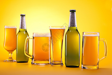 黄色背景的冷冻啤酒金子气泡茶点瓶子液体派对玻璃琥珀色酒吧饮料图片