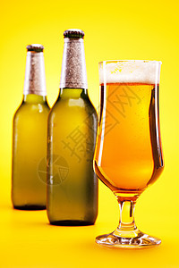 黄色背景的冷冻啤酒琥珀色气泡酒吧茶点液体瓶子冷藏饮料派对玻璃图片