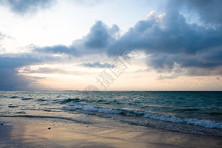 热带日出时的平静海洋和海滩波浪海浪季节地平线天空日落图片