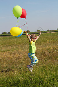小女孩带着气球在田里跑图片