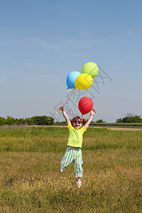 快乐的小女孩 有气球跳上田地场地太阳镜运动女儿乐趣白色青年跑步跳跃微笑图片