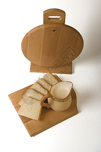 白面板上的面包片和奶罐片 白色背景图片