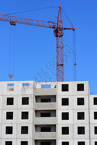 建筑工地上的红色起重机和蓝蓝天空机械生长蓝色黄色建筑学住房金属工程商业技术图片