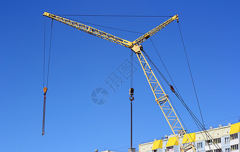 建筑工地上的黄黄色起重机和蓝色天空黄色建筑学生长工程金属起重机住房机械商业技术图片