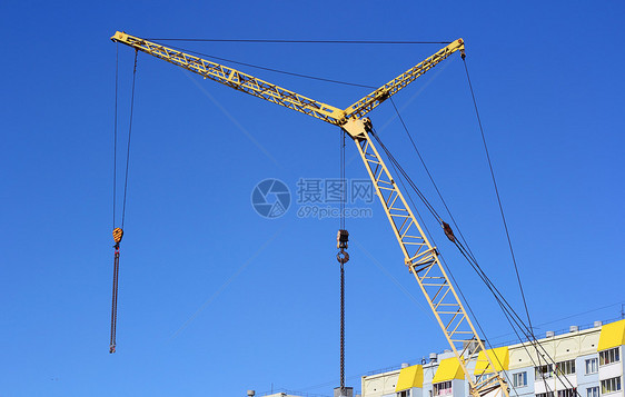 建筑工地上的黄黄色起重机和蓝色天空黄色建筑学生长工程金属起重机住房机械商业技术图片