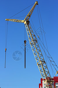 建筑工地上的黄黄色起重机和蓝色天空工程摩天大楼生长机械住房商业金属项目技术黄色图片