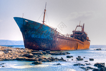 在岩石礁上搁浅的老沉船支撑悬崖货轮损害风化蓝色导航岩石渔船运输图片