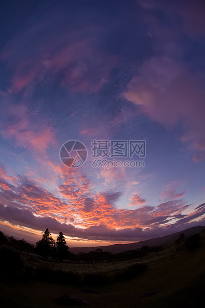 色彩多彩的日落山脉树木场景太阳天空荒野丘陵丛林地平线图片