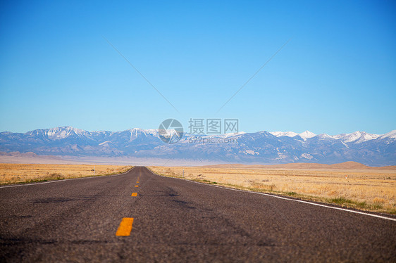 空高速公路驶近山地山脉沙漠自由蓝色天空场景孤独沥青车道城市地平线图片