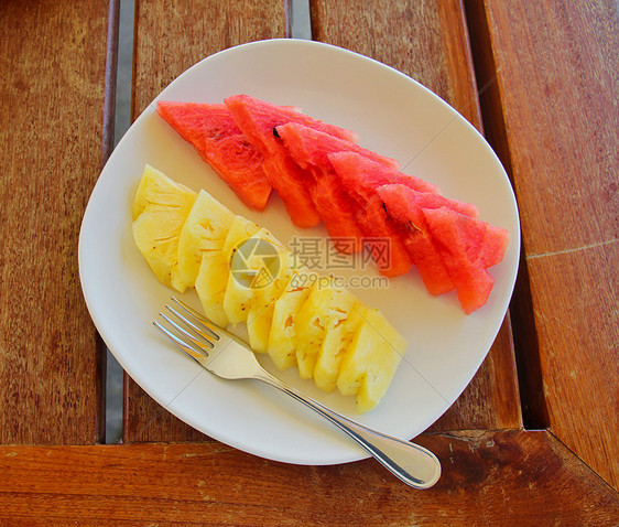西瓜和菠萝在叉子碗上餐厅红色营养食物健康饮食水果桌子果汁盘子餐具图片
