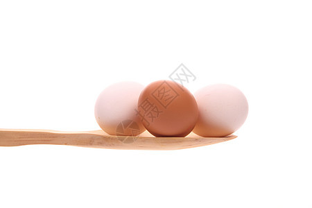 在白色背景上被孤立的木勺子上的鸡蛋厨具奉献杂货工作室蛋壳木头食物炊具美食健康图片
