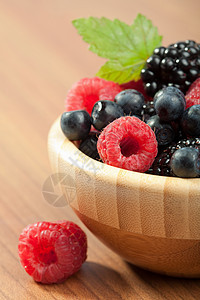 木碗中的新鲜果子覆盆子蔬菜叶子水果荒野蓝色饮食食物木头甜点图片