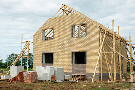 正在建造的砖房材料活动水泥石头脚手架天空窗户框架住房阳光图片