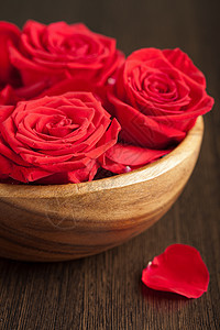 碗中的玫瑰花草本花瓣疗法装饰木头风格粉色反射冥想温泉图片