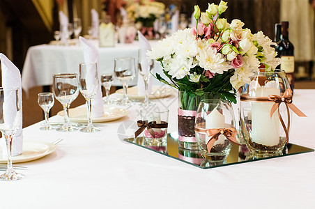 婚礼晚宴的餐桌安排银器盘子花瓶派对奢华餐厅服务蜡烛装饰玫瑰图片
