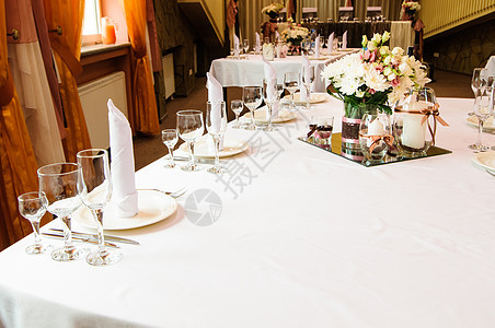 婚礼晚宴的餐桌安排桌布花瓶蜡烛纺织品餐具接待服务丝带玫瑰桌子图片