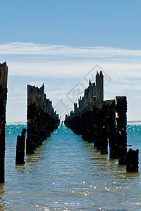 在只有柱子的沙滩上 挂着美丽的腐烂船坞海洋天堂天空码头波浪树干海岸线日落海滨木头图片