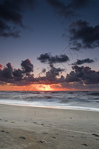 日落时沙滩 天空闪亮冲浪石头反射镜子海洋波浪太阳橙子辉光蓝色图片