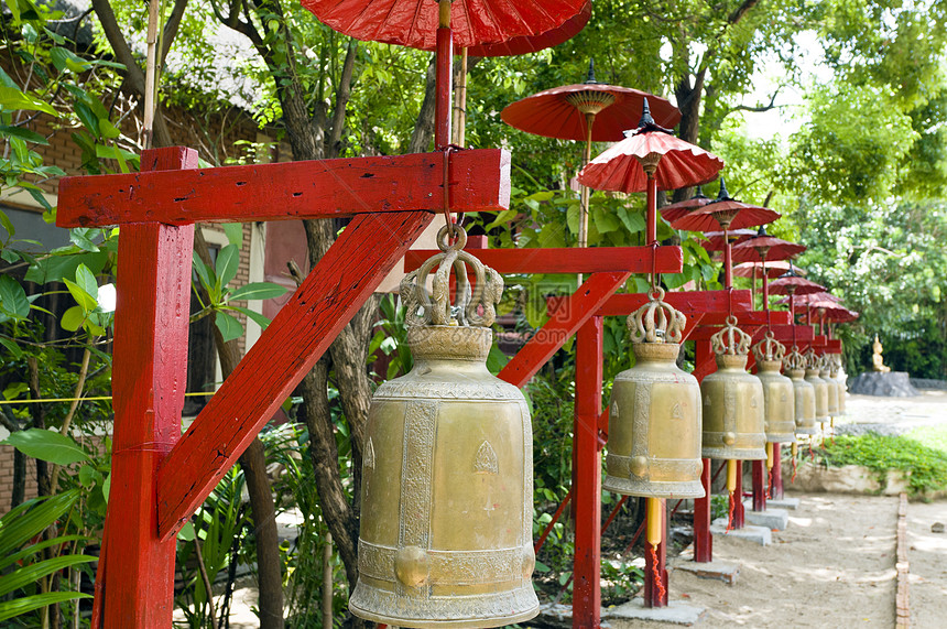 红伞覆盖的寺庙里的一排钟声红金灌木引导神社绿色图片