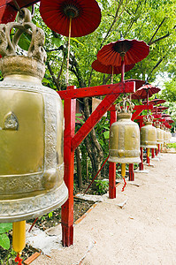 红伞覆盖的寺庙里的一排钟声绿色神社引导红金灌木图片