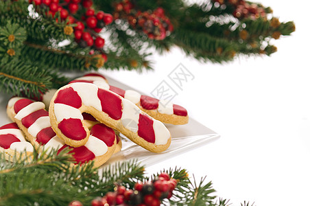以真正的树枝装饰的圣诞饼干手杖浆果糖果甜点装饰品松树盘子食物针叶手工图片