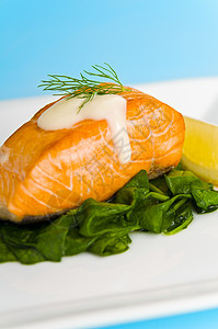 菠菜上的鲑鱼牛排 配上柠檬 和酱汁饮食蓝色白色熏制产品蛋黄鱼片餐具草本植物美食图片