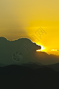 日落在山后面太阳山脉极限水平橙子光线黄色地形薄雾天空图片