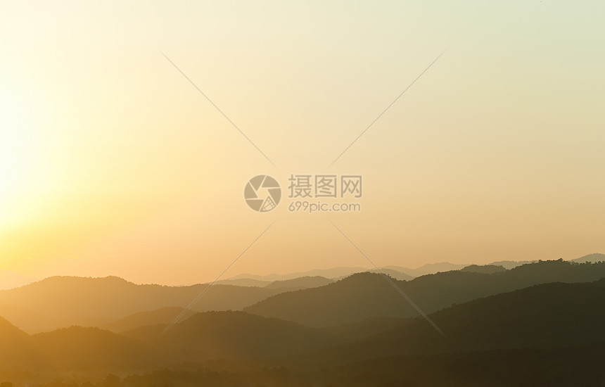 日落在山后面地形地平线黄色山脉阳光光线薄雾场景背光橙子图片