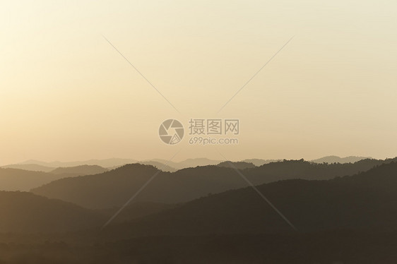 日落在山后面极限天空水平背光顶峰太阳光线黄色山脉风景图片