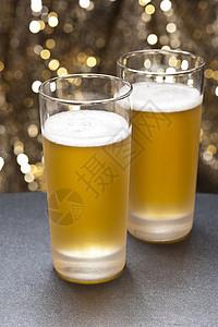 在色彩多彩的背景面前的杯子庆典酒精黄色奢侈酒吧啤酒杯酒馆味道餐厅泡沫图片