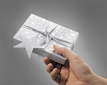 送给你的礼物光盘盒装庆典丝带盒子展示手指惊喜星星灰色背景图片