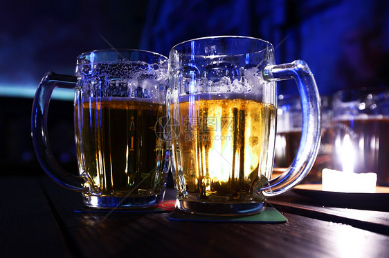 在黑暗中的啤酒生活酒精派对泡沫反射液体餐厅火焰玻璃金子图片