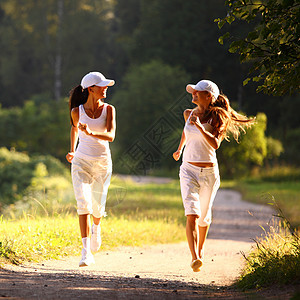 参加竞选的妇女慢跑头发树木赛跑者娱乐跑步行动公园女士运动装图片