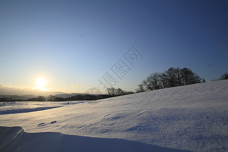 雪田和山丘太阳场地白色日落雪原阳光旅行天空蓝色图片