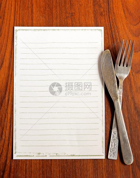 用刀和叉在木制背景上的菜单纸图片