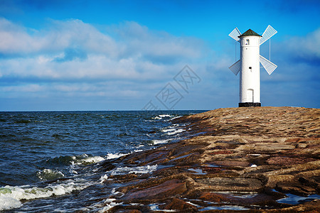 Swinoujscie的灯塔阳光风车海岸线历史性地标天空房子海滩海岸建筑图片
