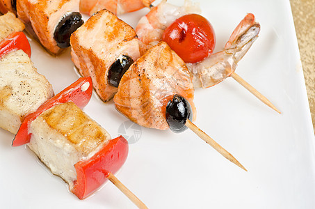 烤鲑鱼和虾烧烤叶子胡椒油炸沙拉宏观盘子餐厅海鲜草药图片