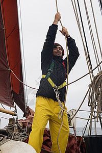 工作时年轻水手力量甲板成人绳索帆船赛活动职业索具工人巡航图片