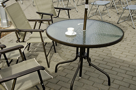 桌椅和人行道上的空咖啡杯图片