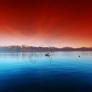 湖上游艇崎岖帆船涟漪海岸线村庄环境蓝色天空反射山脉图片