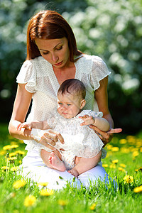 母亲和女儿在绿草上妈妈女士婴儿花朵女孩孩子男生青年晴天公园图片