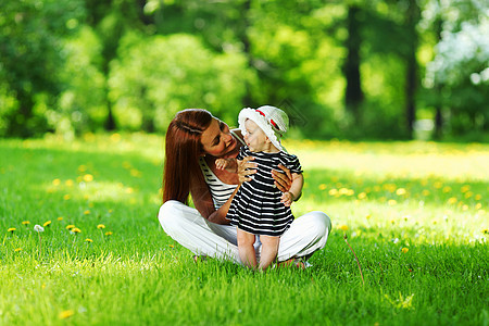 母亲和女儿在绿草上女性孩子乐趣夫妻花朵童年女士女孩妈妈公园图片