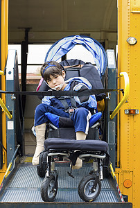 乘坐校车轮椅电梯的残疾小男孩男生婴儿车人士机动性公共汽车民众脑瘫残障安全带学校图片