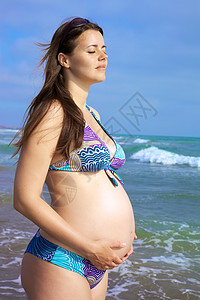 怀着肚子的孕妇在海面前图片
